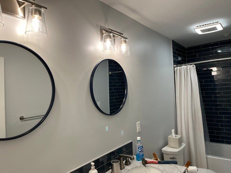 Remodeled residential bathroom with double vanity and mirrors