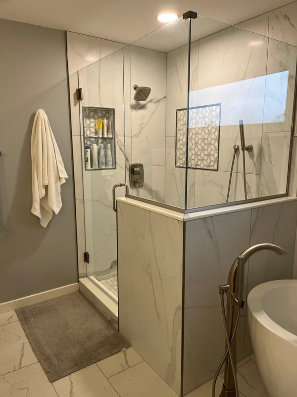 Tiled shower with glass door and marble vanity