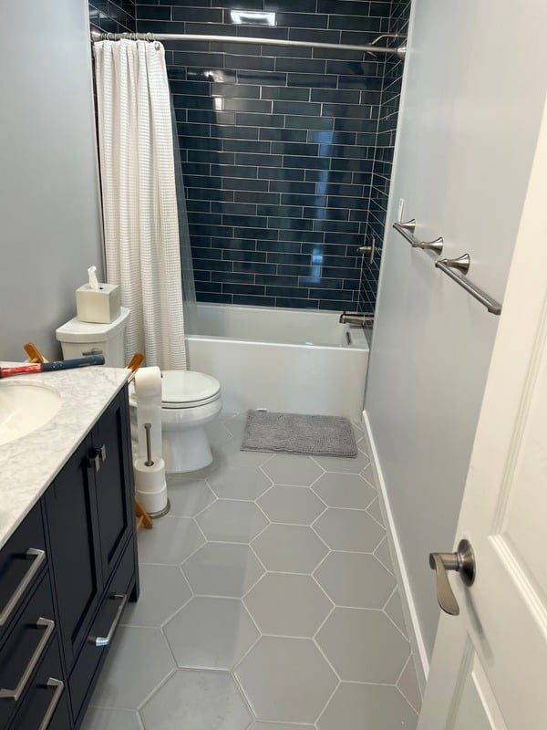 Navy tile bathroom with soaking tub